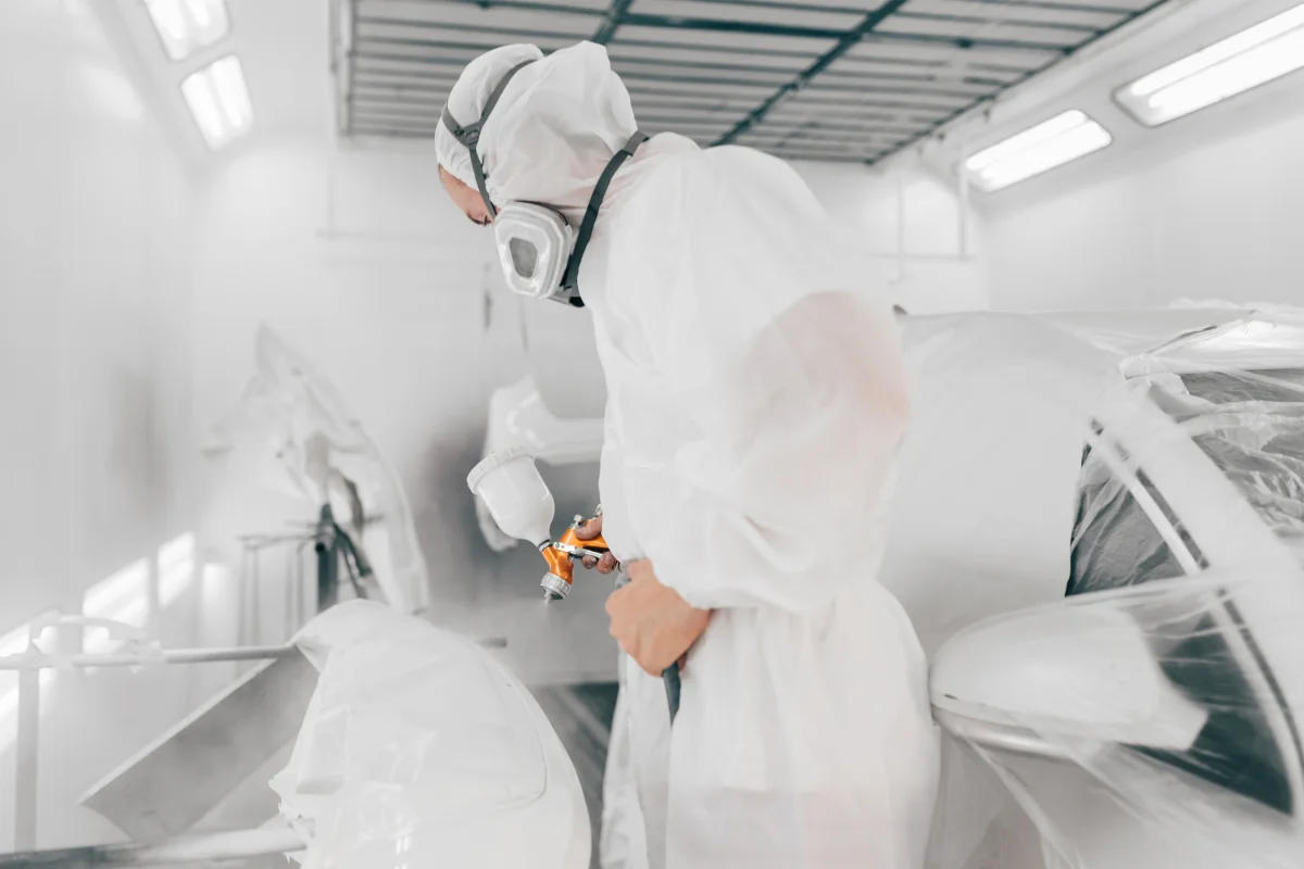 Technician applying Peelclear in a spray booth